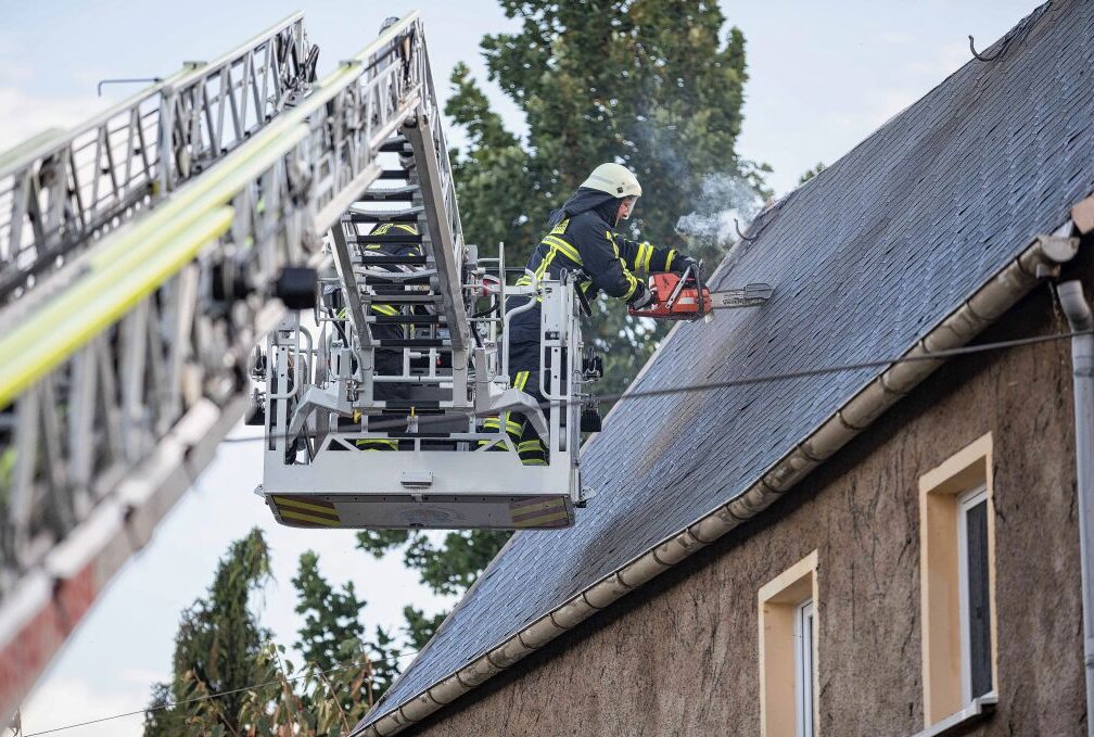 Dachstuhlbrand in Siebenlehn: Hubschrauber fliegt 73-Jährigen in Klinik - Um die Glutnester besser löschen zu können, schnitt die Feuerwehr das Dach auf. Foto: Marcel Schlenkrich