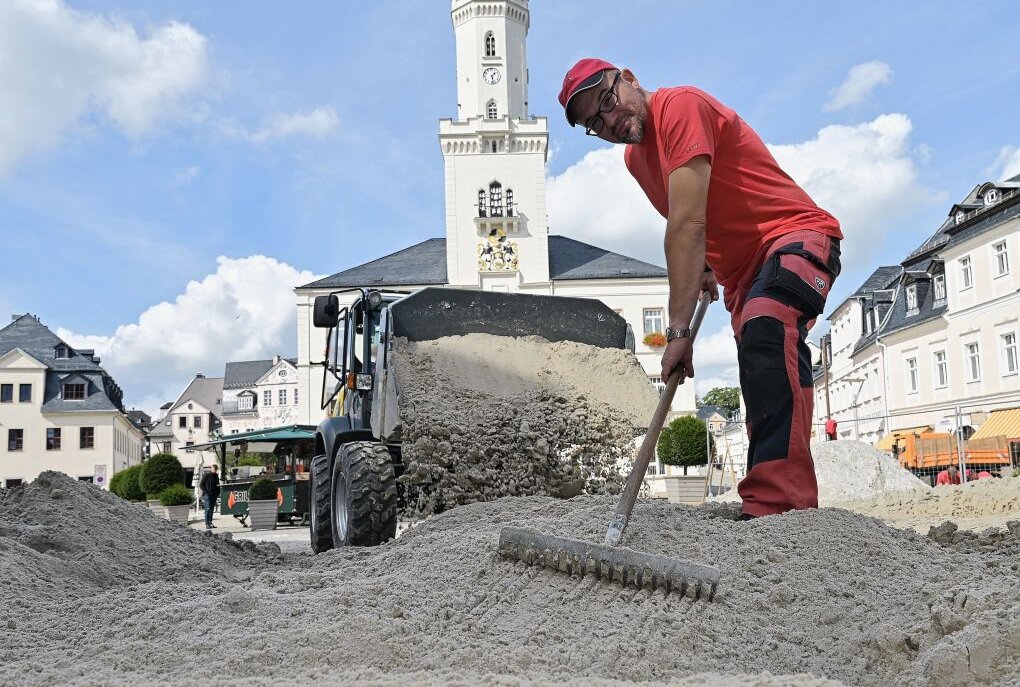 Gestern ist der Sand fürs Beachvolleyball-Turnier in Schneeberg auf die Spielfelder verteilt worden - im Bild Daniel Thuß, Mitarbeiter der Firma Lenk aus Schneeberg. Foto: Ralf Wendland