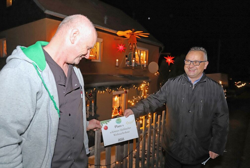 Das ist Halsbachs schönstes Weihnachtshaus - Mario Kark (li.) erhält die Ehrentafel für das am weihnachtlichsten geschmückte Haus in Halsbach.Foto: Wieland Josch