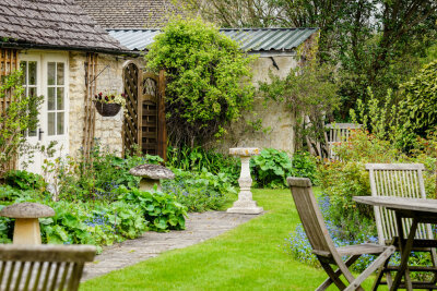 Das sind die Garten-Trends 2022 - Den Garten im Cottage Style zu gestalten bedeutet viele Bauernmöbel, viele bunte hohe Blumen und die Pflanzen auch an Wänden hochklettern zu lassen.