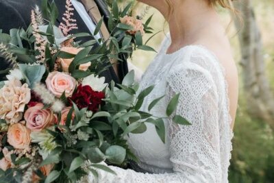 Auch in diesem Jahr ist der Boho-Brautstrauß mit unkonventionellen üppige Blumen, die sowohl frisch als auch getrocknet sein können. Durch ein oder zwei Farbtöne setzt die Braut einen Akzent. Passend zu dem Brautstrauß gibt es einen Anstecker für den Bräutigam und Haarschmuck.