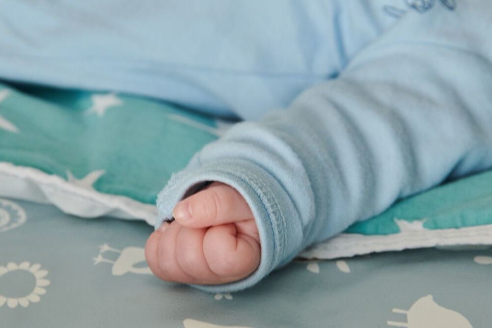 Baby: Die Hand eines Babys ist zu einer kleinen Faust geballt.