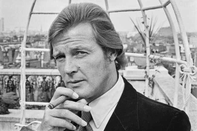 Da stand er, der neue Bond: Der britische Schauspieler Roger Moore (1927 - 2017) posierte im August 1972 auf dem Dach des Dorchester Hotels in London. Zusammen mit den Produzenten Albert R. Broccoli und Harry Saltzmansprach er über seine neue Rolle.