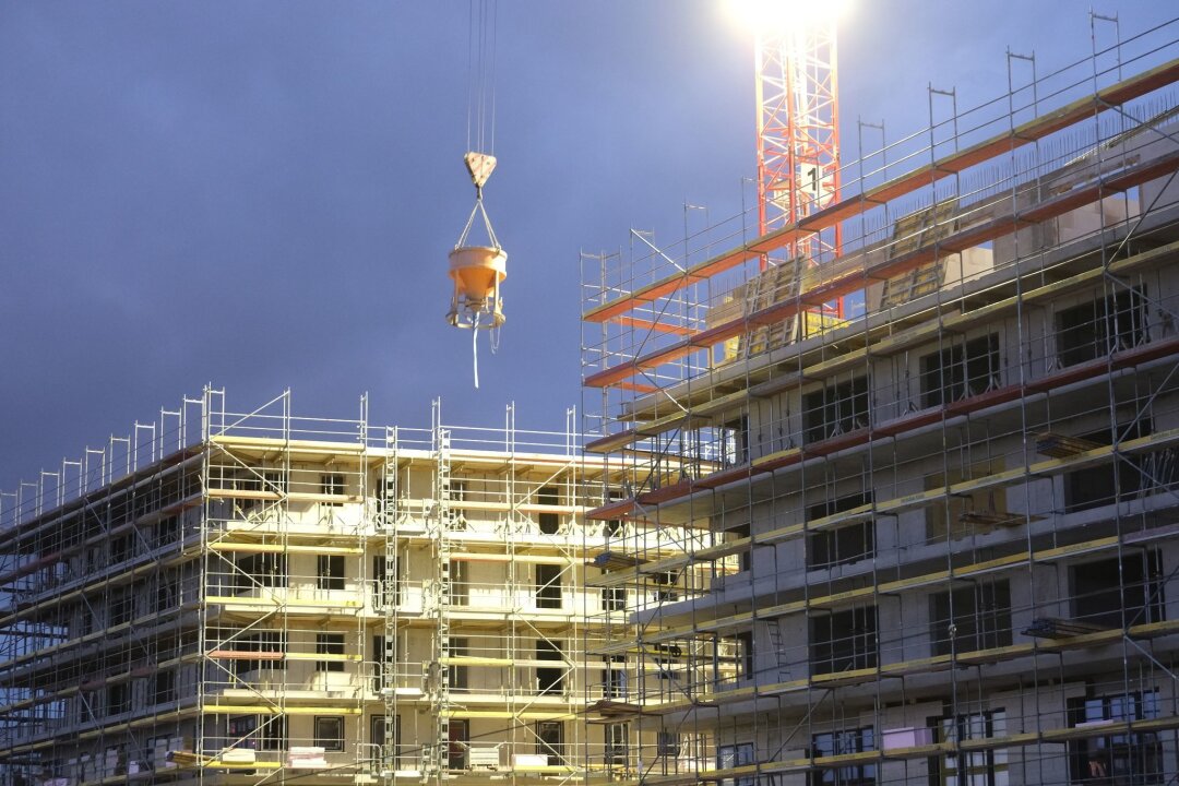 Deutlich weniger Baugenehmigungen in Sachsen - Rohbauten für Wohnhäuser werden in der Dämmerung beleuchtet.