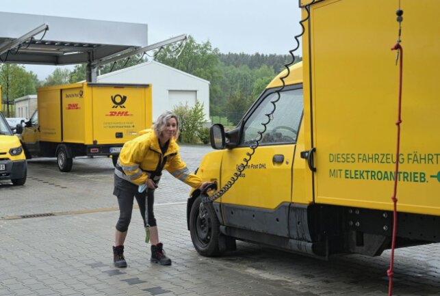 Am Zustellstützpunkt der Deutsche Post DHL Group in Eibenstock - im Bild Zustellerin Susan Baldauf beim Laden eines E-Zustellfahrzeuges. Foto: Ralf Wendland