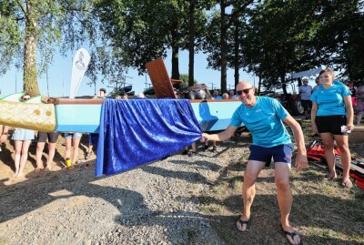 Drache zum Leben erweckt: Bootstaufe am Pöhler Stausee - Vereinsmitglied Uwe Möckel zieht zur Taufe das Tuch vom Boot. Foto: Thomas Voigt