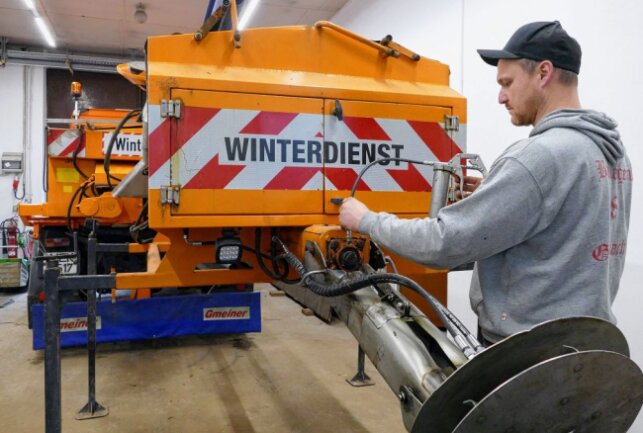 Hier befestigt Bauhof-Mitarbeiter Michel Petzold einen Salzstreuer an einem der Transporter. Foto: Andreas Bauer