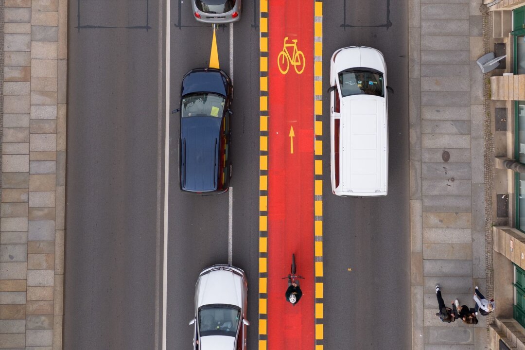 Dresdner Verkehrsversuch wird kontrovers diskutiert - Autos stehen an der Elbbrücke Blaues Wunder an einem rot markierten Radweg.