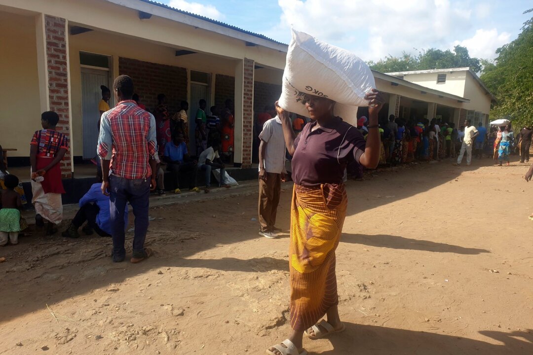 Dürre: Simbabwe erklärt Katastrophenzustand - Eine Frau trägt einen Sack mit Maismehl, den sie in einem Verteilungszentrum des Welternährungsprogramms erhalten hat: Im südlichen Afrika wurde der Notstand ausgerufen.
