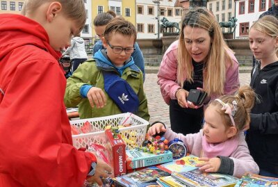 Ein voller Erfolg: Kinder-Koffer-Flohmarkt in Freiberg - Mila Bruchmüller war mit 3 Jahren auf Suche nach Lieblingsspielzeug, bei Ives und Quentin (rote und grüne Jacke) wurde sie fündig. Foto: Christof Heyden