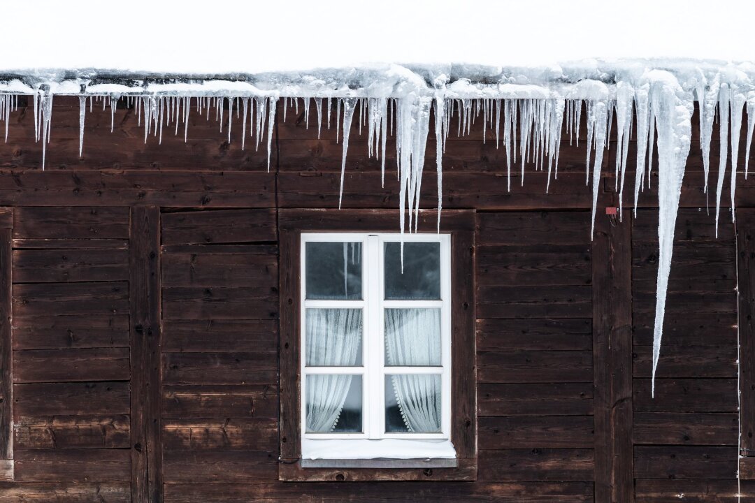 Eis und Schnee: Feuchteschäden am Haus vermeiden - Eiszapfen sind ein Anzeichen für verstopfte Dachrinnen. Wenn Tauwetter einsetzt, kann das Wasser an den Rinnenkanten herunterlaufen und den Putz durchfeuchten.