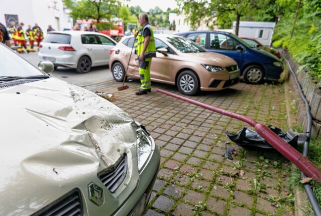 Aus ungeklärter Ursache fuhr ein E-Auto einen Hang hinunter und krachte in parkende Autos. Foto: B&S David Rötzschke
