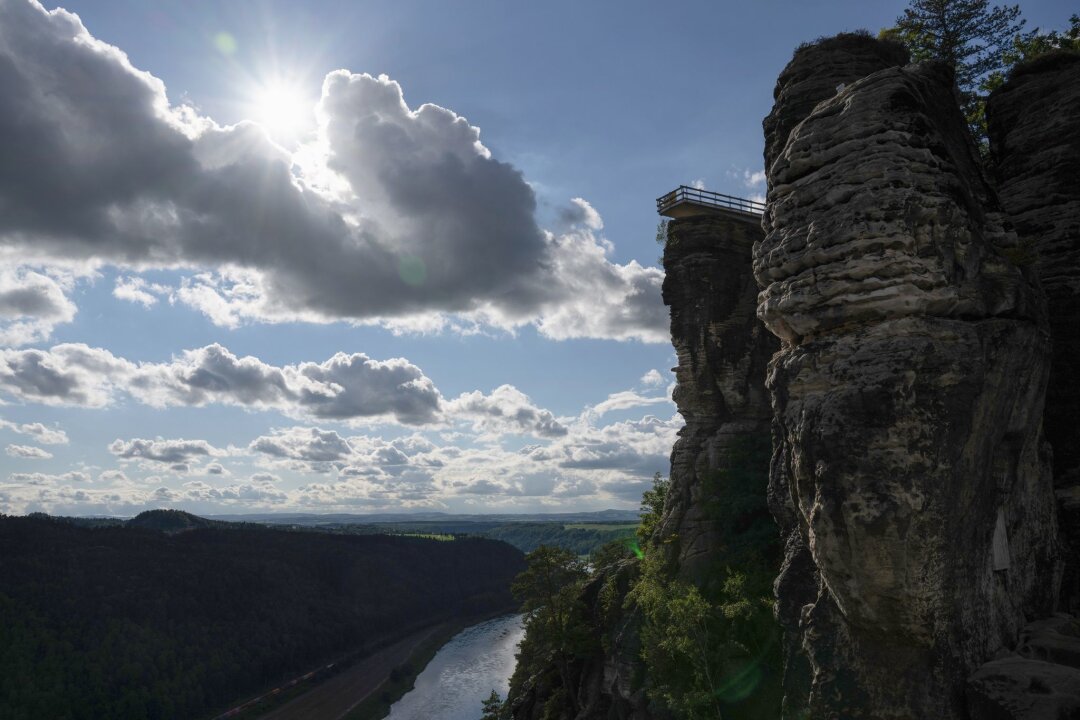 Ermittlungen zu Waldbrand in Sächsischer Schweiz - Der neue Aussichtssteg der Bastei zeichnet sich im Elbsandsteingebirge im Nationalpark Sächsische Schweiz im Gegenlicht der Sonne als Silhouette ab.