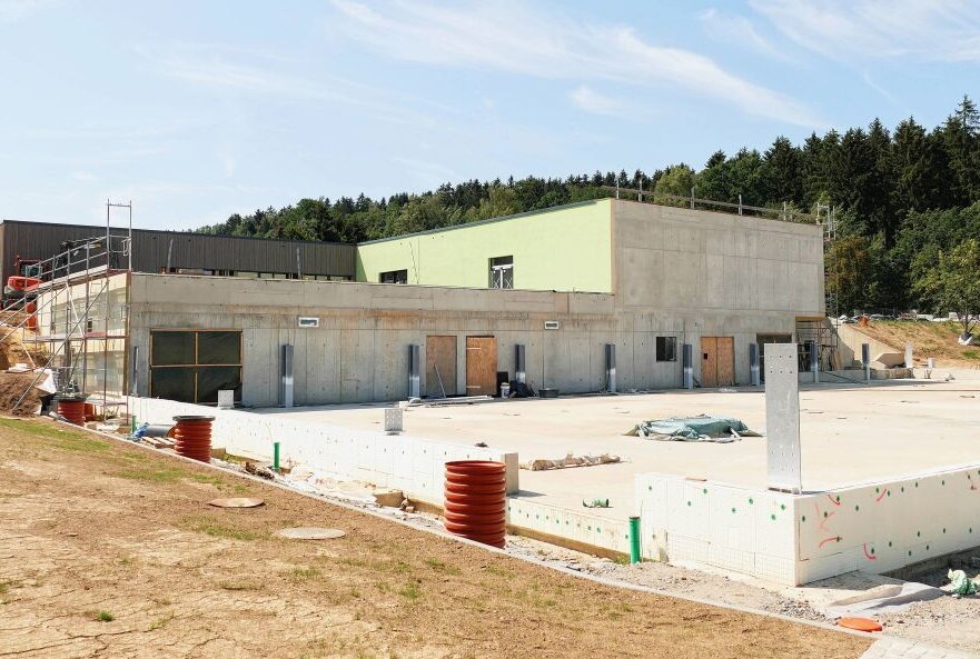 Der Bodenbelag in der neuen Grünhainichener Grundschule wird deutlich später verlegt als geplant. Auch von der Turnhalle (vorn) ist bislang nur die Bodenplatte zu erkennen. Foto: Andreas Bauer
