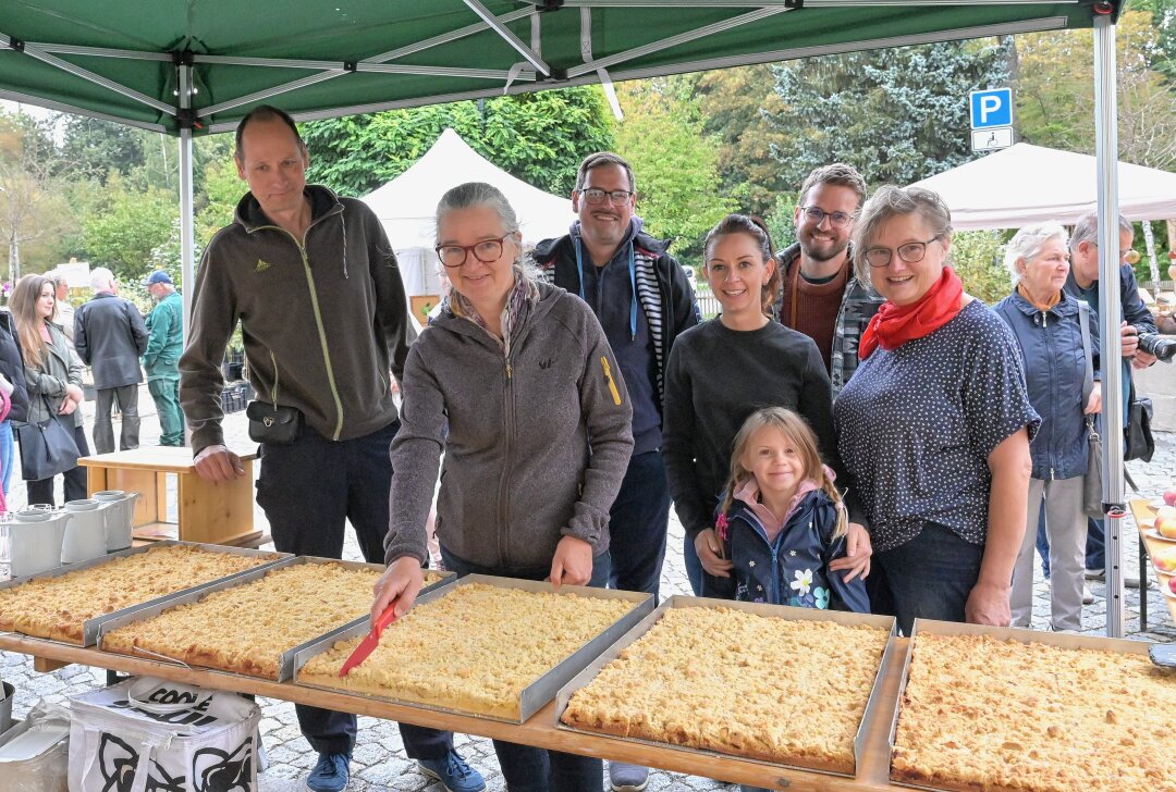 Erzgebirger backen Riesenapfelkuchen aus 57 verschiedenen Sorten - In Lößnitz ist ein Riesenapfelkuchen angeschnitten worden - beim Anschnitt Anja Markert (2.li.) vom Lößnitzer Apfelprojekt. Foto: Ralf Wendland