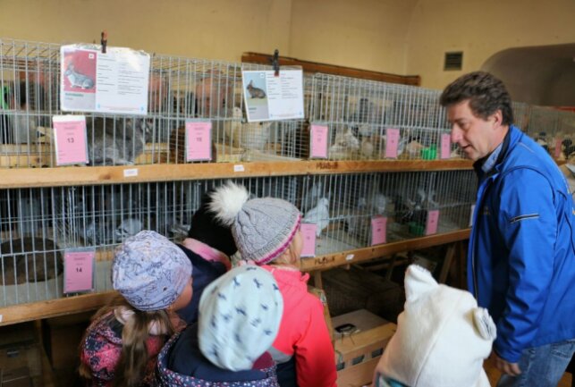Fachsimpeln, feilschen und feiern zum Taubenmarkt - Maik Lorenz vom Mühltroffer Verein führte die Kindergartenkinder aus dem Ort durch den Markt, zeigte die Tauben, Kaninchen und Ziervögel. Foto: Simone Zeh