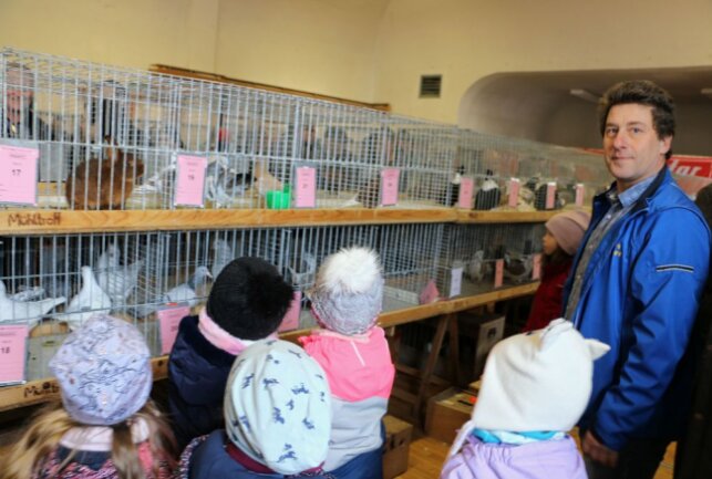 Fachsimpeln, feilschen und feiern zum Taubenmarkt - Maik Lorenz vom Mühltroffer Verein führte die Kindergartenkinder aus dem Ort durch den Markt, zeigte die Tauben, Kaninchen und Ziervögel. Foto: Simone Zeh