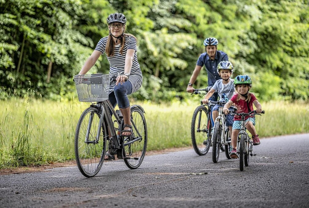 Familie bei einer Radtour im Sommer durch den Stadtpark. Foto: Ralph Kunz