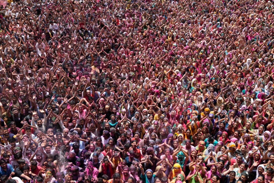 Farbe, Cannabis und schlagende Frauen: Indien feiert Holi - Gläubige jubeln während der Holi-Feierlichkeiten im Kalupur Swaminarayan-Tempel.