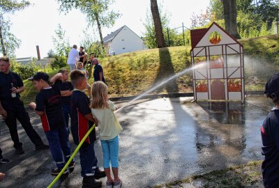 Die Feuerwehrkinder zeigen ihren Altersgenossen, dass man beim Löschen zielen muss. Foto: Renate Fischer