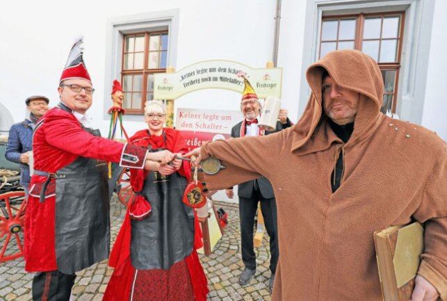 Freibergs Oberbürgermeister Sven Krüger (r.) als Mönch übergibt den Rathausschlüssel an das Prinzenpaar Marko I. und Melanie I. (v.l.) Foto: Wieland Josch