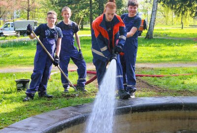 Frühjahrsputz in Flöha: Brunnen im Baumwollpark sprudelt wieder - Die Jugendfeuerwehr Flöha kümmerte sich unter anderem um die Reinigung und Befüllung des Brunnen. Foto: Knut Berger