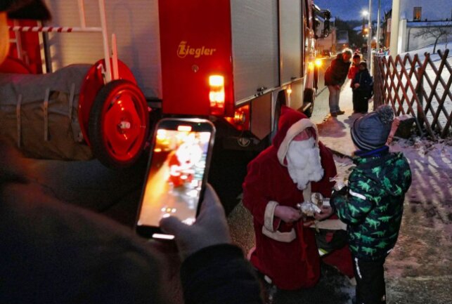 Gelenauer Feuerwehr hilft dem Nikolaus aus der Klemme - Viele Eltern hielten den Besuch des Nikolaus, der per Feuerwehrauto unterwegs war, auf einem Handy-Foto fest. Foto: Andreas Bauer