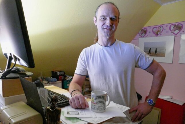 An seinem Computer hat Heiko Neubert lange am Aussehen der Tasse und den Begriffen getüftelt. Foto: Andreas Bauer