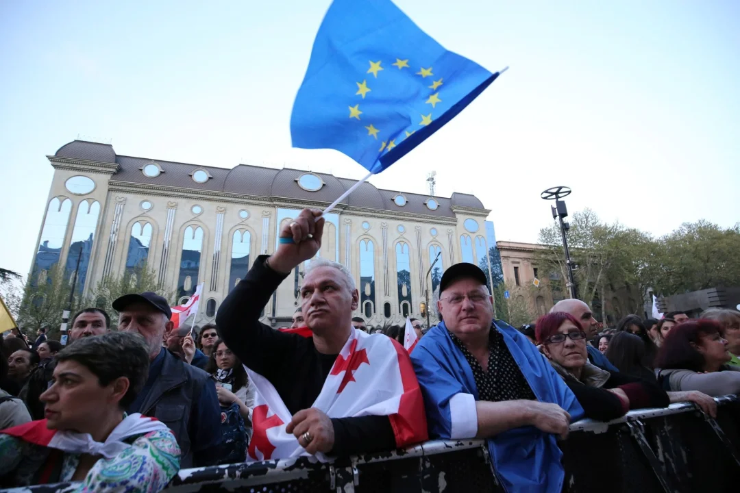 Georgiens Parlament treibt umstrittenes Gesetz voran - Mit EU- und Georgien-Flagge: Menschen protestieren in Tiflis gegen das umstrittene Gesetz.