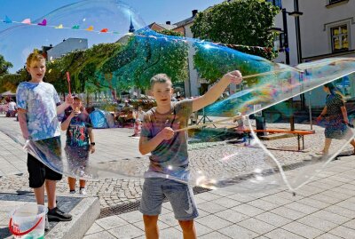 Gesellige Brunch-Runden am Sonntag vor Rathaus in Treuen - Gut gelaunt experimentieren die Jungs mit Riesenseifenblasen. Foto: Thomas Voigt