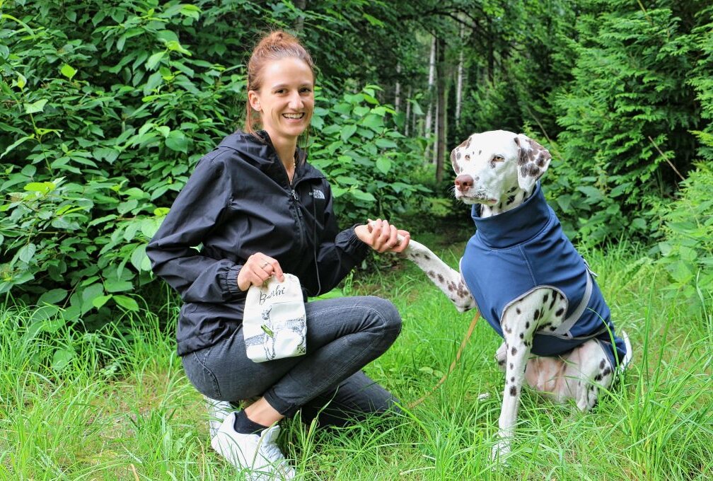 Julia Rammler mit Gassitasche und Hund Resi. Dieser trägt einen maßgeschneiderten Mantel. Foto: Simone Zeh