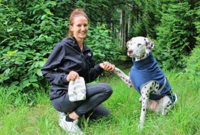 Grünbacherin schneidert Maßkleidung für Vierbeiner - Julia Rammler mit Gassitasche und Hund Resi. Dieser trägt einen maßgeschneiderten Mantel. Foto: Simone Zeh