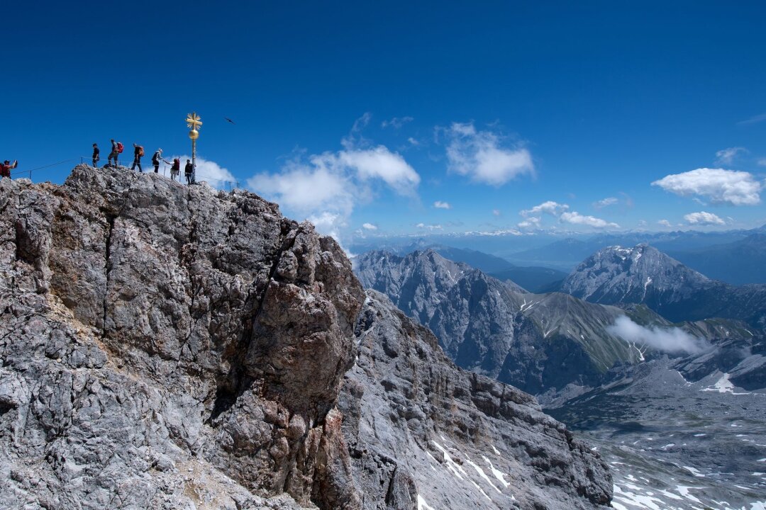 Hoch, höher, höhenkrank? - Bergsteiger am Gipfelkreuz der Zugspitze: In dieser Höhe (2962 m) braucht der Körper schon etwas länger, um sich anzupassen.