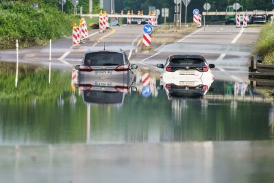 Hochwasser im Südwesten - Aufräumen und abwarten - Zwei Autos stehen unter einer Saarbrücke in Saarbrücken im Hochwasser.