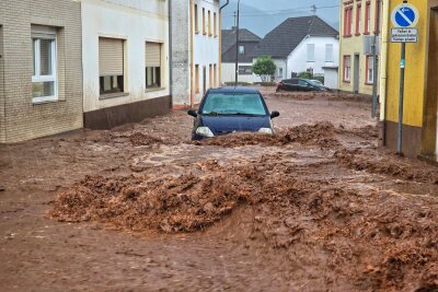 Hochwasser im Südwesten - Aufräumen und abwarten - Ein Auto bahnt sich den Weg durch die Wassermassen in Kirn.