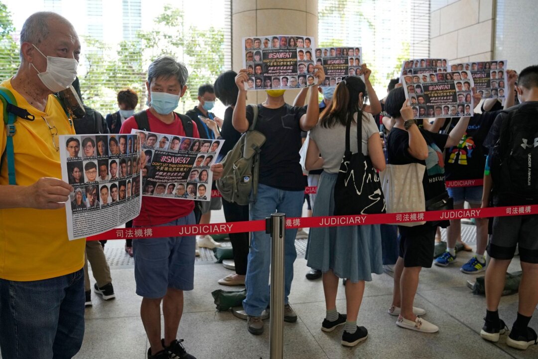 "Hongkong 47": 14 Demokratie-Aktivisten schuldig gesprochen - Unterstützer halten vor einem Gericht in Hongkong Plakate mit den Fotos einiger der 47 angeklagten Demokratie-Aktivisten in die Höhe.