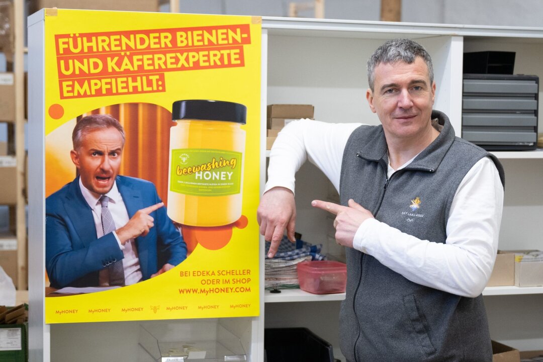 Honig-Streit mit Böhmermann geht im Juni in nächste Instanz - Rico Heinzig, Imker, steht neben einem Plakat mit dem Foto des Moderators Jan Böhmermann.