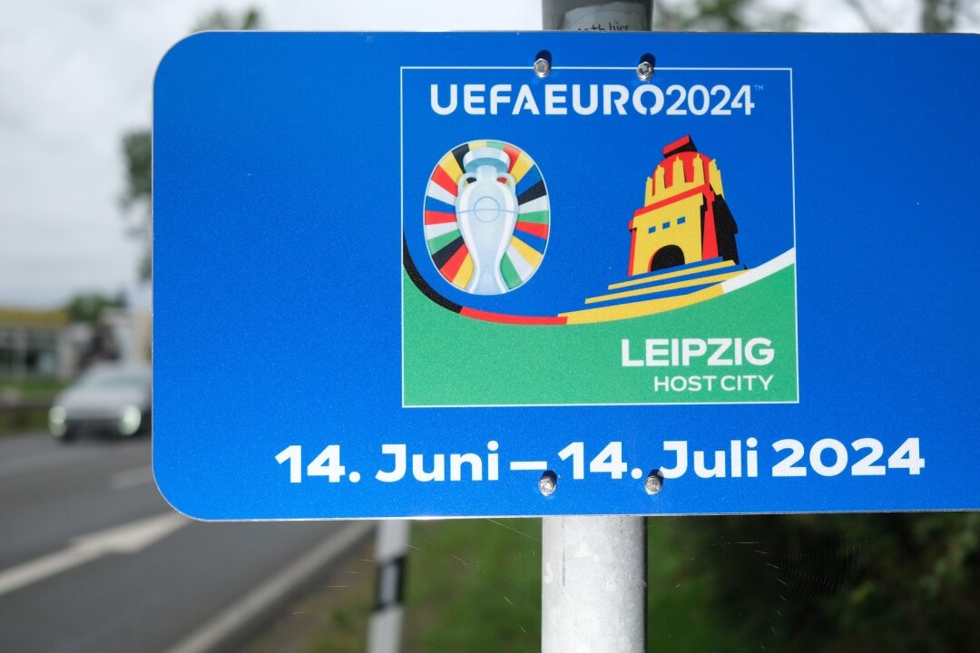Hotelbetten während der Fußball-EM fast ausgebucht - Eine Tafel zur kommenden Fußball-EM ist ergänzend am Ortseingangsschild angebracht. Leipzig ist einer der Austragungsortes des Turnieres.