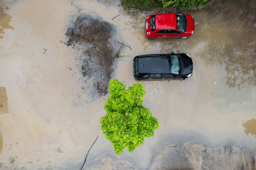 Hunderte Einsätze nach Gewittern und heftigen Regenfällen - Autos stehen auf einem überschwemmten Parkplatz  in Frankfurt am Main.