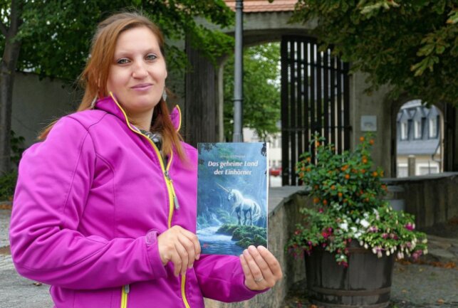 Stolz präsentiert Jenny Hoffmann ihr erstes Buch: "Das geheime Land der Einhörner". Foto: Andreas Bauer