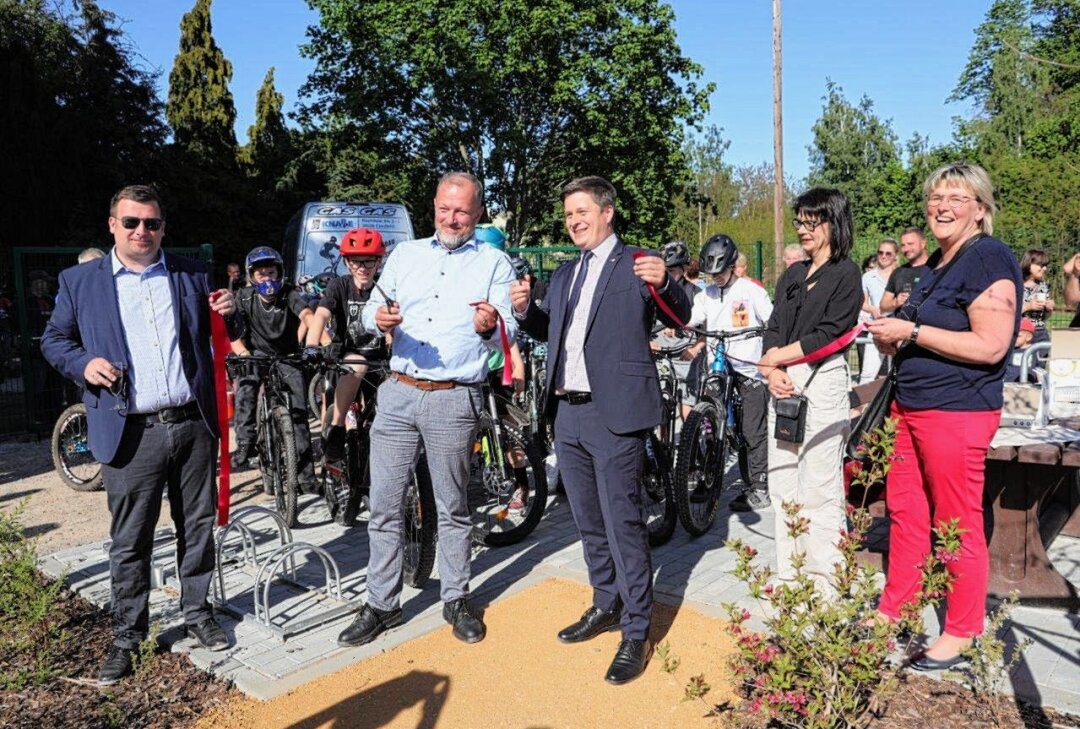 In diesem mittelsächischen Ort können Biker nun endlich fahren und springen - Bürgermeister André Wolf (Mitte r.) sowie René Heinicke (Mitte li.), Ausbildungsleiter von Flenders durchtrennten das Band für den neuen Bikerpark in Penig. Foto: Andrea Funke