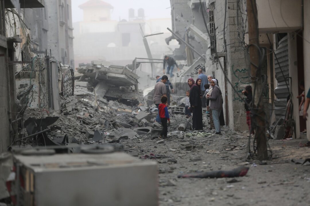 Israel kündigt "sofortige" Aufstockung von Gaza-Hilfe an - Menschen versammeln sich auf den Trümmern eines zerstörten Gebäudes nach einem Luftangriff im Flüchtlingslager Maghazi im Zentrum des Gazastreifens.