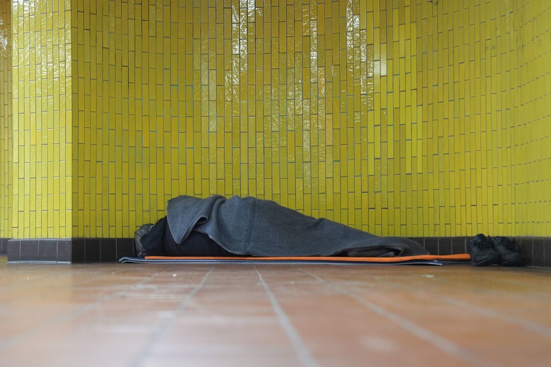 Jeder Fünfte von Armut oder sozialer Ausgrenzung bedroht - Ein Obdachloser liegt in seinem Schlafsack in einer U-Bahnstation in der Hamburger Innenstadt. 17,7 Millionen Menschen waren 2023 in Deutschland von Armut oder Ausgrenzung bedroht.