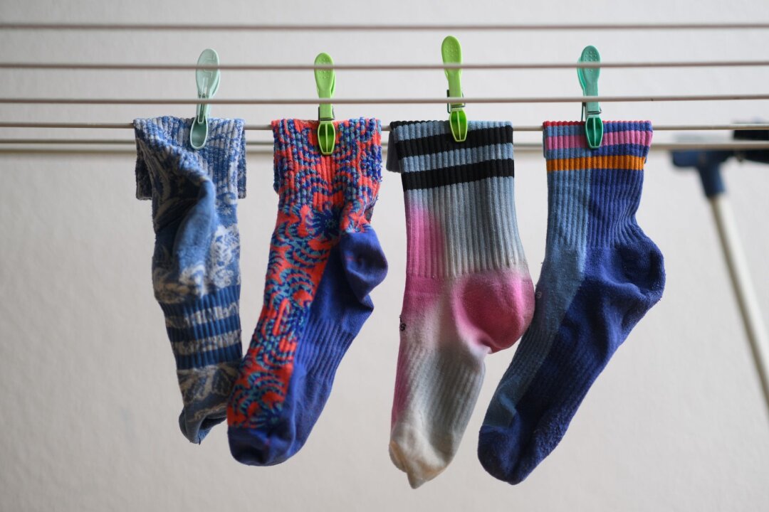 Kann die Waschmaschine Socken fressen? - Bunte Socken hängen auf einem Wäscheständer. Am 9. Mai ist Tag der verschwundenen Socken.