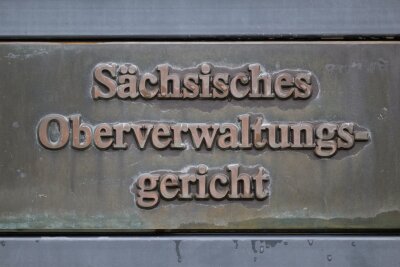 Kaum noch Corona-Verfahren an Sachsens Verwaltungsgerichten - Ein Schild „Sächsisches Oberverwaltungsgericht“ steht vor dem Gebäude auf dem Gelände der Ortenburg.