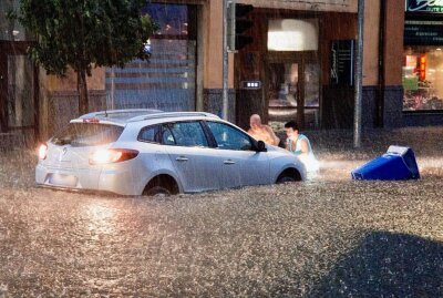 Keller in Aue steht regelmäßig unter Wasser: Rechtsstreit seit 2007 - Personen versuchen ihr Auto vor der Überschwemmung zu retten. Foto; Daniel Unger/Archiv