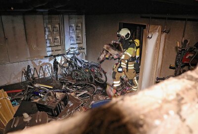 Kellerbrand in Mehrfamilienhaus sorgt für Polizeieinsatz - Anschließend beförderten sie verbranntes Altpapier ins Freie. Foto: Roland Halkasch