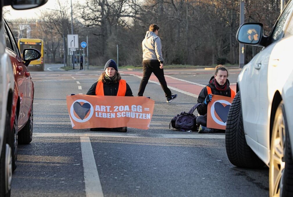 Klima-Aktivisten blockieren erneut Dresdner Stadtverkehr - Klima-Aktivisten kleben sich auf Dresdner Straße fest.Foto: Roland Halkasch
