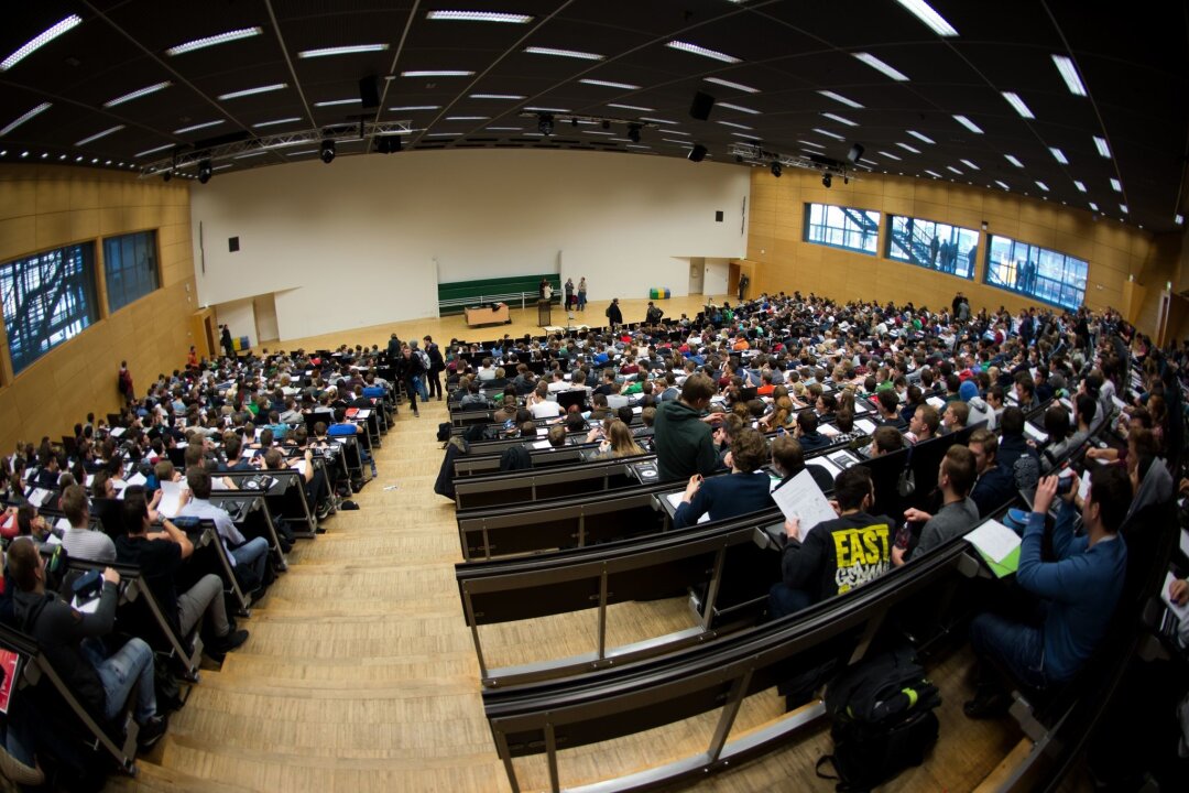 KMK: Zahl der Studienanfänger soll in Sachsen wieder steigen - Studierende sitzen am Tag der offenen Hochschultür in einem Hörsaal.