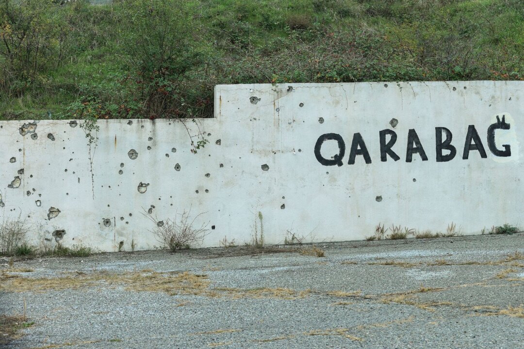 Kreml bestätigt Truppenabzug aus Karabach im Kaukasus - Spuren des Konflikts: Wand mit Einschusslöchern und dem Schriftzug Karabach.